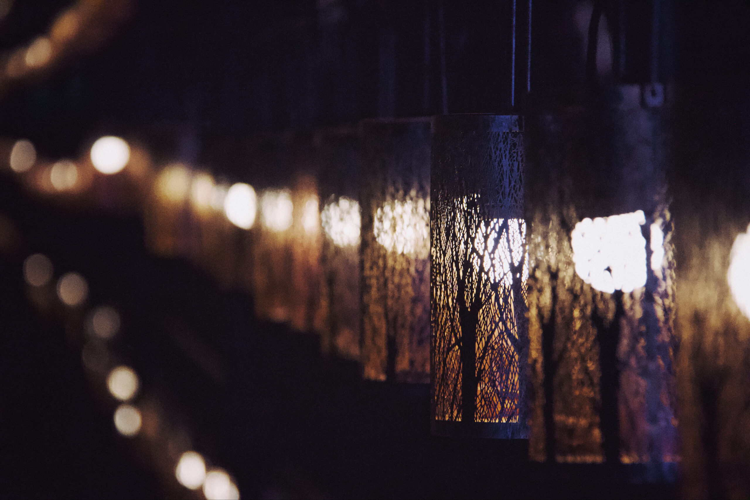 Lanterns casting soft light along a dark corridor