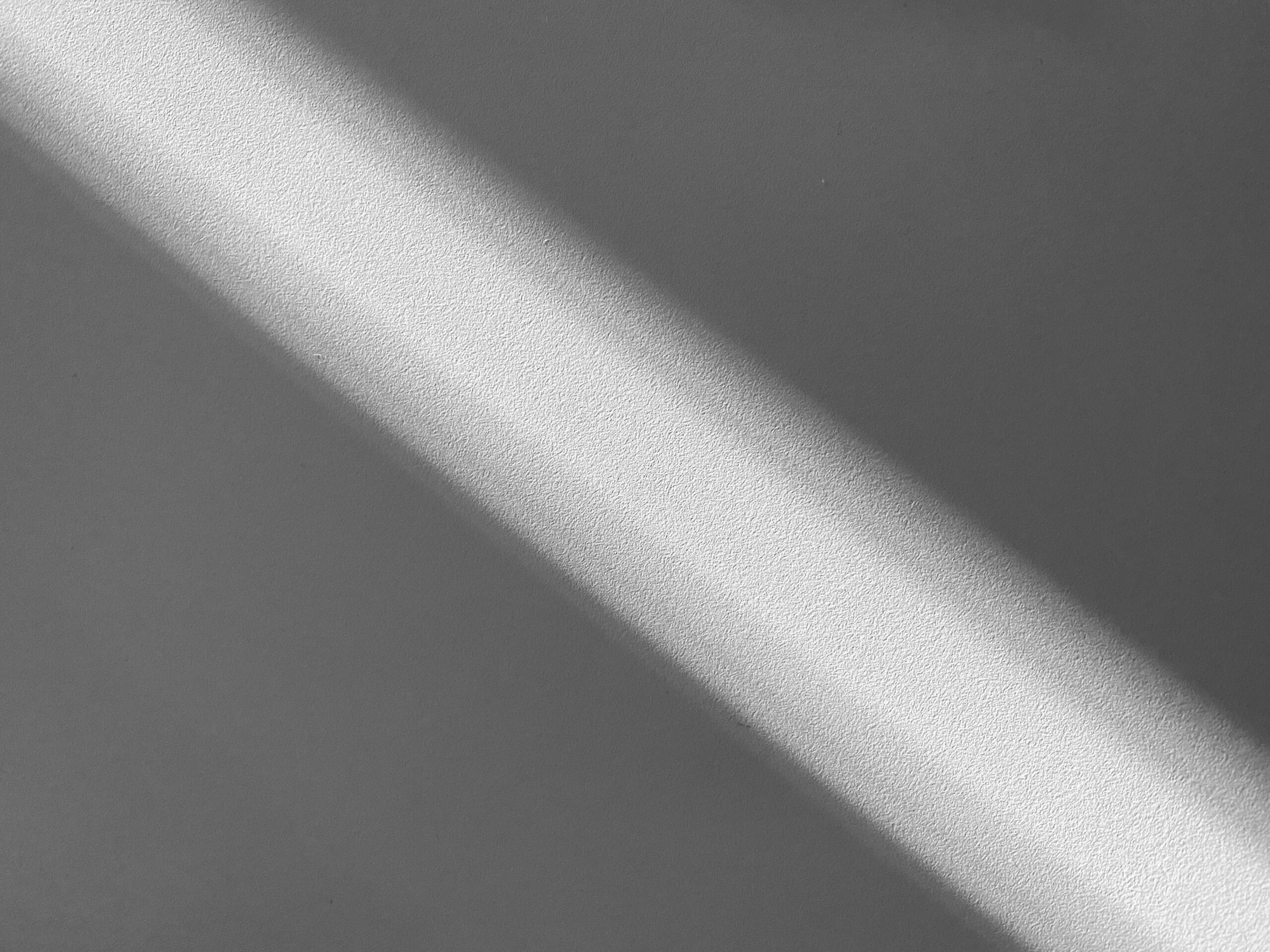 Diagonal band of light across a textured wall